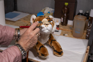 Finition artisanale d’une peluche tigre réaliste cousue main dans l’atelier italien de La Pelucherie, haut de gamme, marque française, La Pelucherie