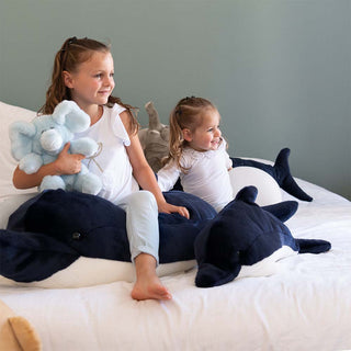 Peluches animaux, dauphin et éléphant, sur un lit avec des enfants, savoir-faire, magasin peluche, La Pelucherie