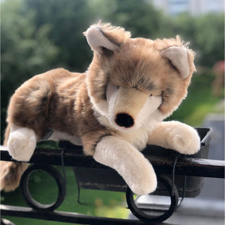 Petit loup en peluche allongé, lifestyle sur un balcon, réaliste, boutique France, La Pelucherie